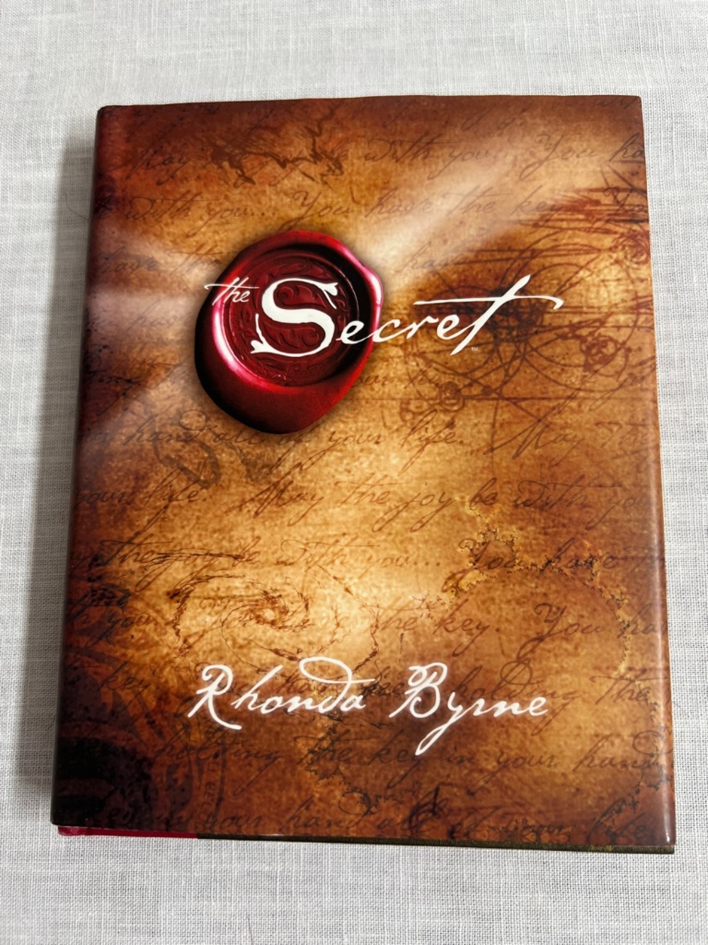 The Secret by Rhonda Byrne — Brown Cover with Red Sealyg
